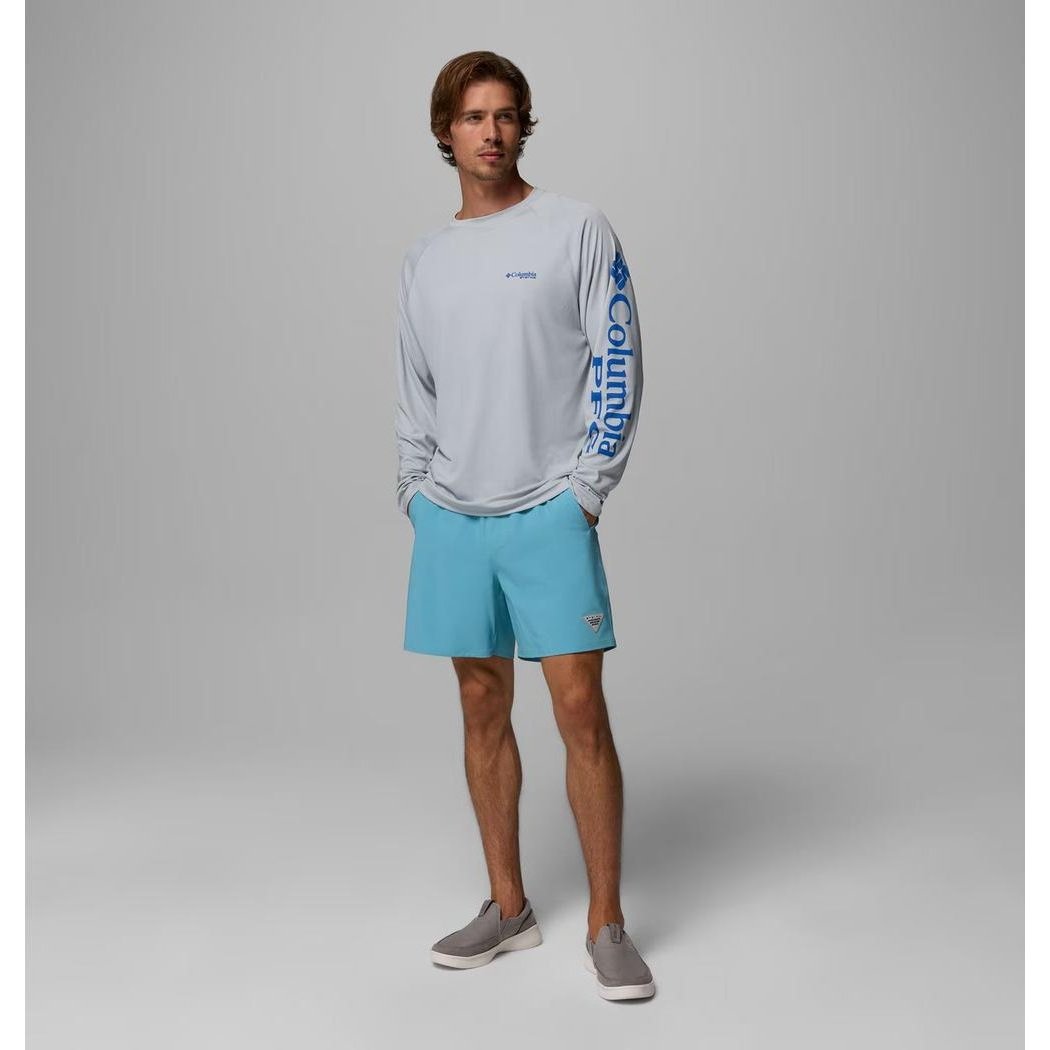 A model wearing the Columbia Sportswear Men's Terminal Roamer Stretch Short in Vintage Blue stands against a plain gray background.