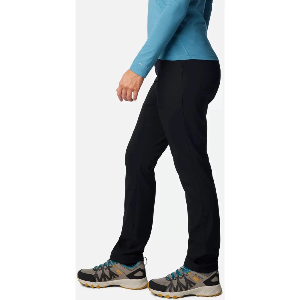 Side view of the Columbia Sportswear Women's Back Beauty High-Rise Pant in Black on a model wearing athletic shoes against a white background.