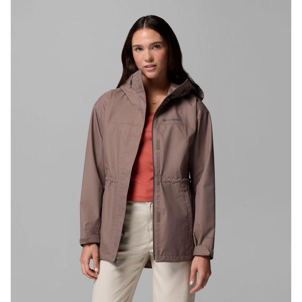 A woman wearing the Columbia Sportswear Women's Hikebound II Long Jacket in Iron stands against a gray background.