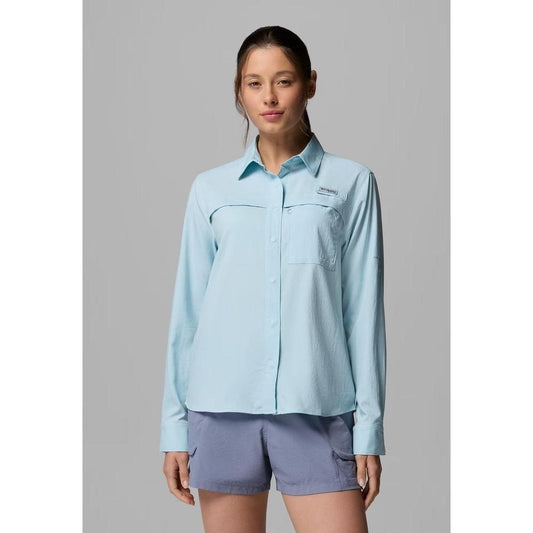 A woman wearing the Columbia Sportswear Women's PFG Castback Woven Long Sleeve in Marine Light stands against a plain gray background.
