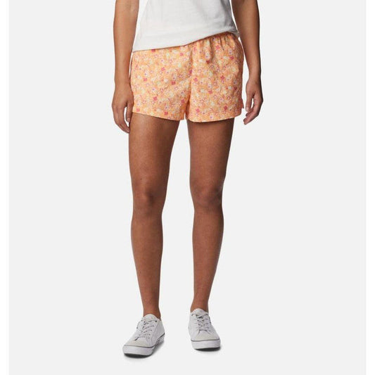 A front view of the Columbia Sportswear Women's Sandy River II Printed Short in Peach, Mini Hibiscus on a model wearing white sneakers against a white background.