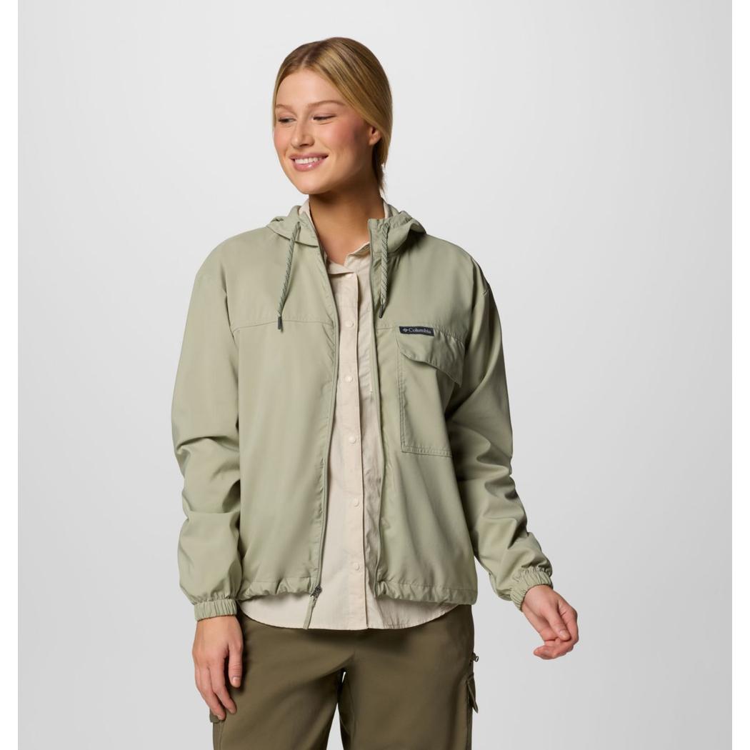 A woman wearing the Columbia Sportswear Women's Skien Valley Hooded Long Sleeve Shirt in Lavender Pearl stands against a plain background.