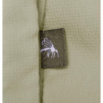 A close-up of the Columbia Sportswear Women's Skien Valley Hooded Long Sleeve Shirt in Lavender Pearl showing the charcoal tag with a white graphic on the olive fabric.