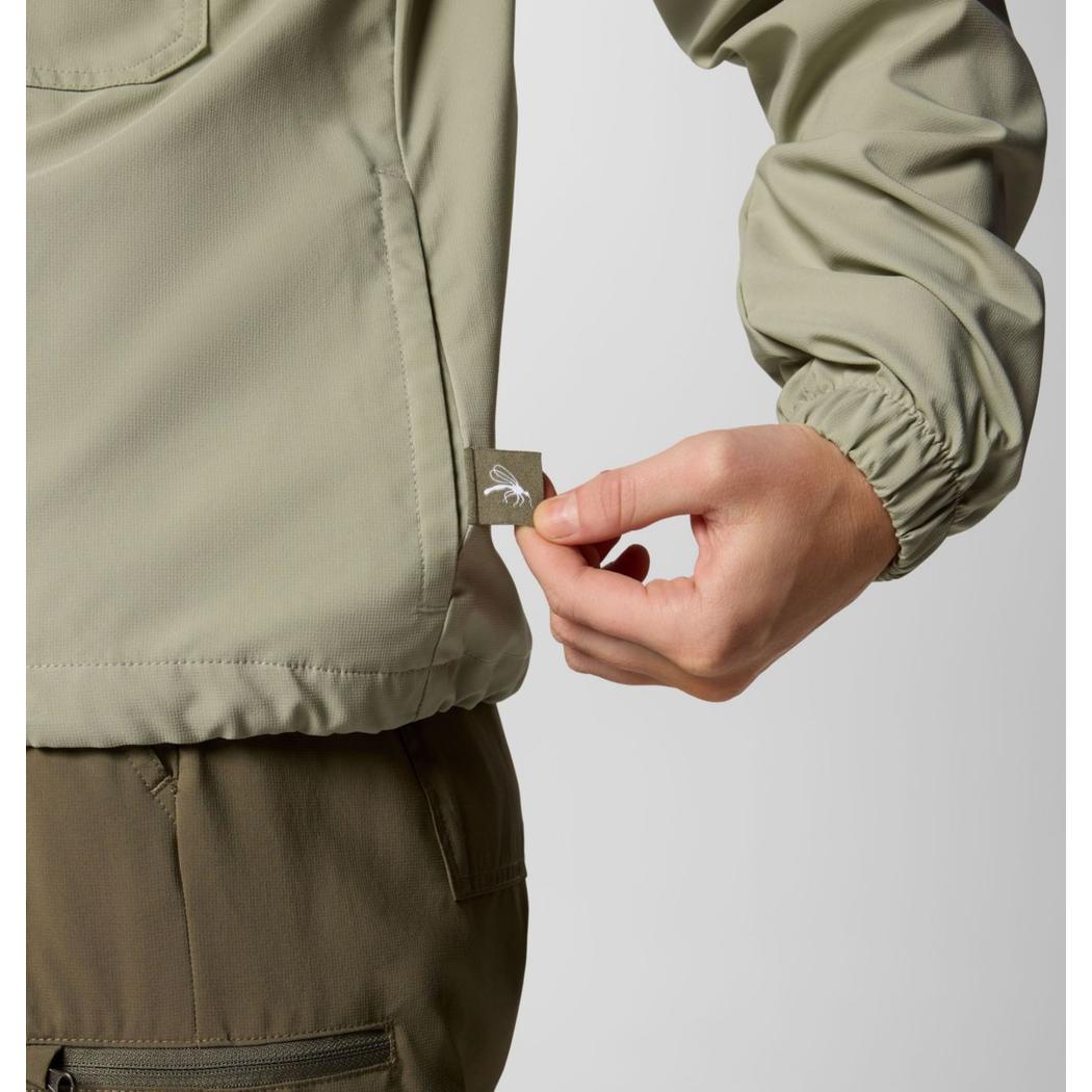 A woman’s hand pulls the tag on the Columbia Sportswear Women's Skien Valley Hooded Long Sleeve Shirt in Lavender Pearl against a plain background.