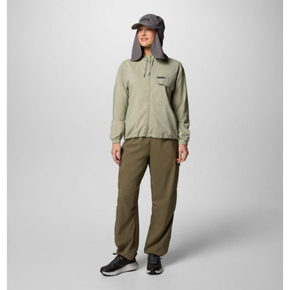 A woman wearing the Columbia Sportswear Women's Skien Valley Hooded Long Sleeve Shirt in Lavender Pearl stands against a light gray background.