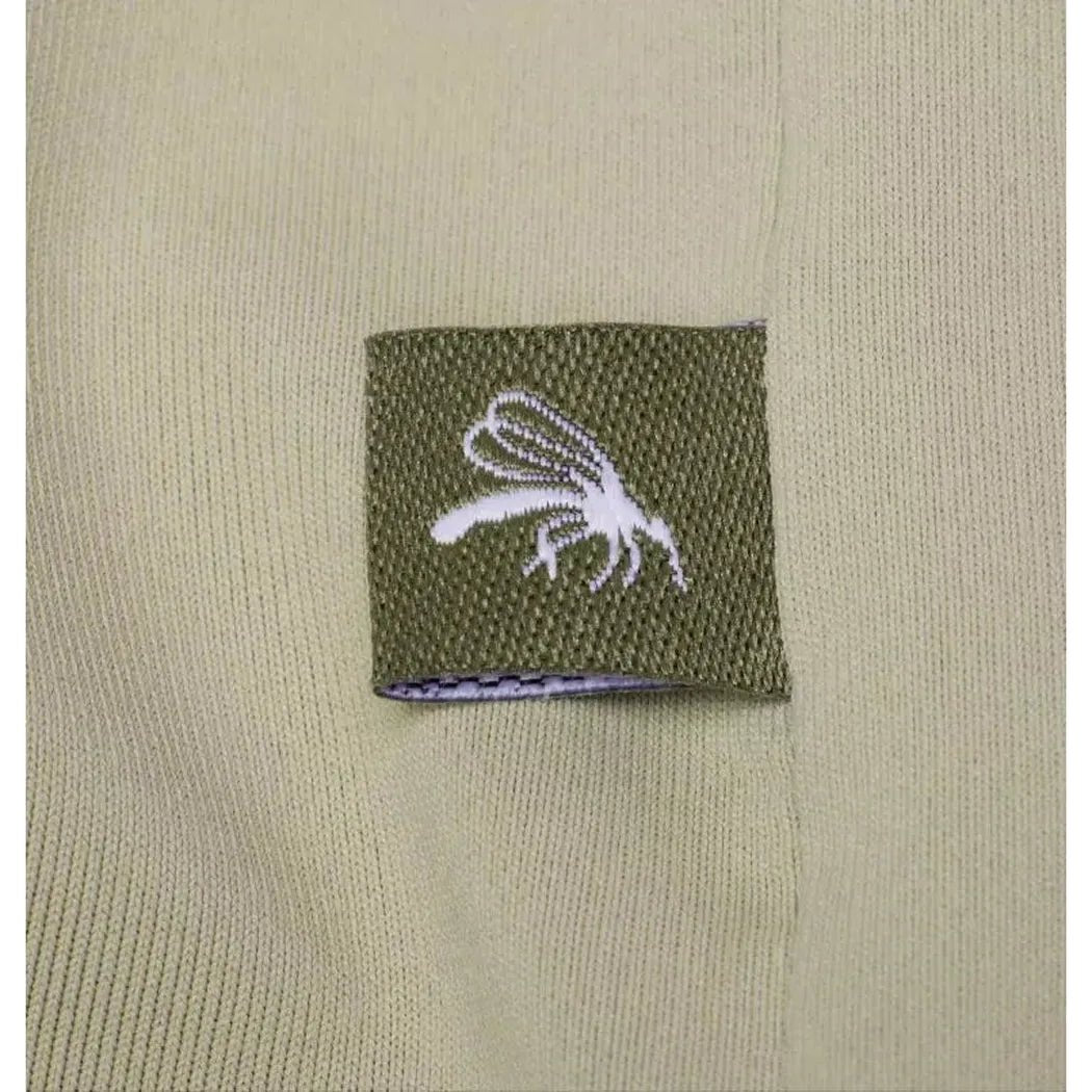 A close-up of the Columbia Sportswear Women's Skien Valley Hoodie in White, showing the olive green tag with a white fly logo against the light-colored fabric.