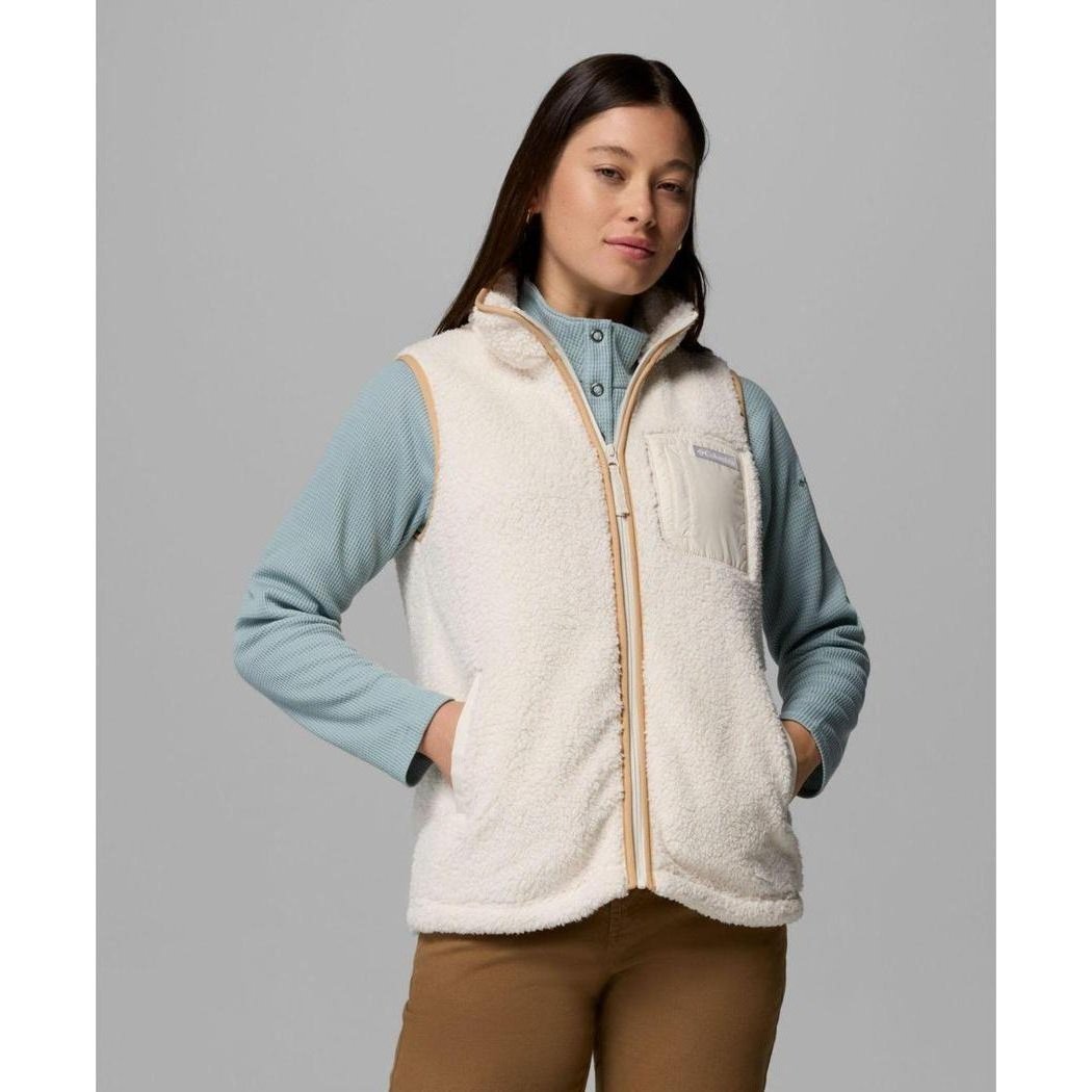 A front view of the Columbia Sportswear Women's West Bend Fleece Vest II in Chalk, showing the model wearing it with a light blue shirt and brown pants against a gray background.