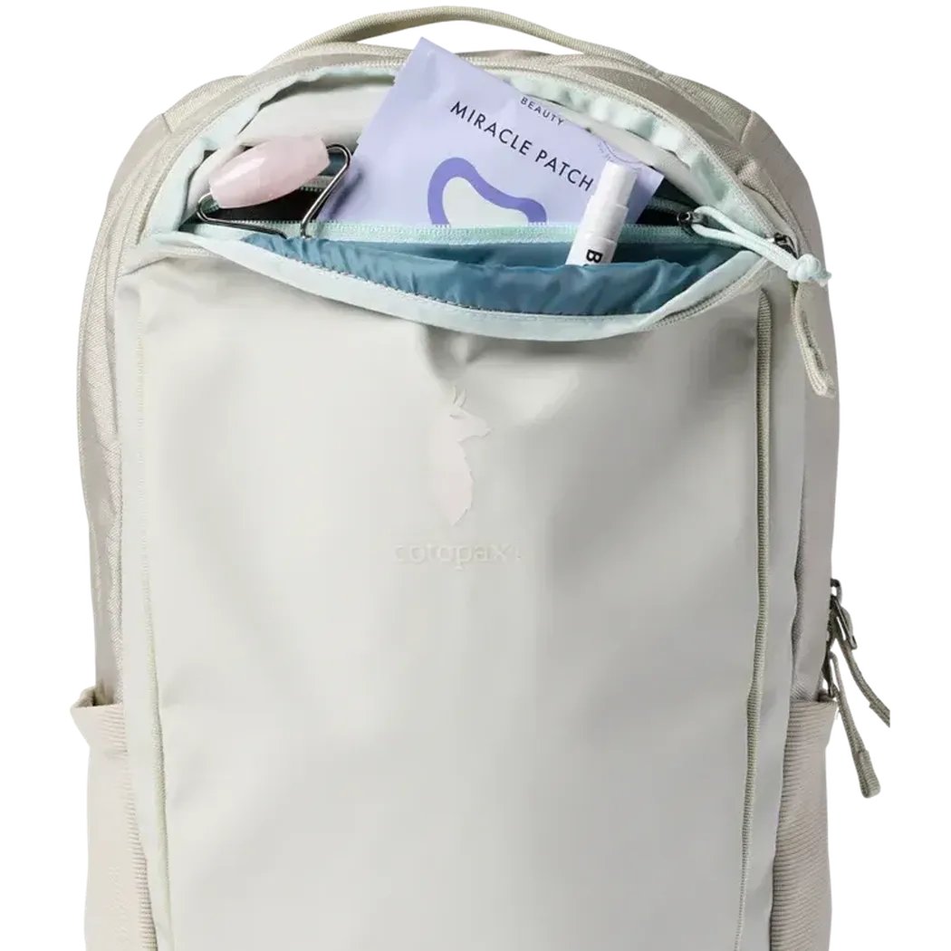 The Mineral Cotopaxi Allpa 18L Daypack shown from the front with its top pocket open, displaying a Miracle Patch and lip balm inside.
