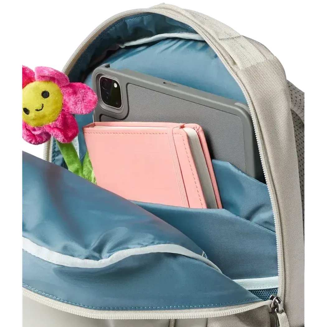 Back view of the Cotopaxi Allpa 18L Daypack in Mineral showing the front pocket with a phone, notebook, and a stuffed flower inside.