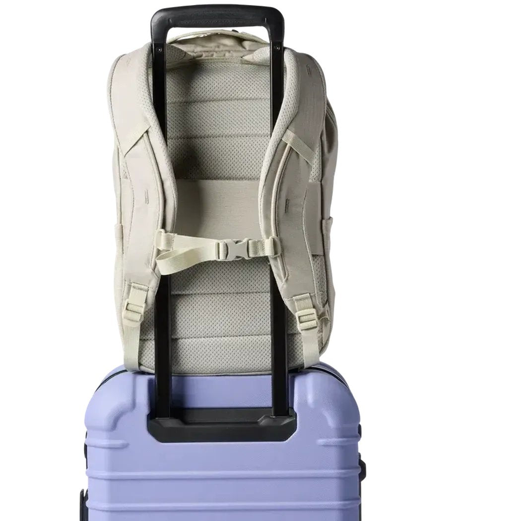 Back view of the Cotopaxi Allpa 18L Daypack in Mineral on top of a light purple suitcase against a white background.