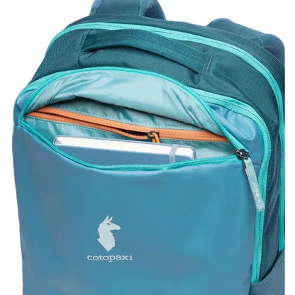 A close-up of the Cotopaxi Allpa 26L Daypack in Blue Spruce/Abyss showing the front pocket with a tablet inside.