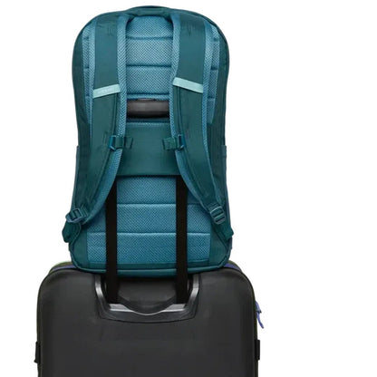 Back view of the Cotopaxi Allpa 26L Daypack in Blue Spruce/Abyss on top of a charcoal suitcase.