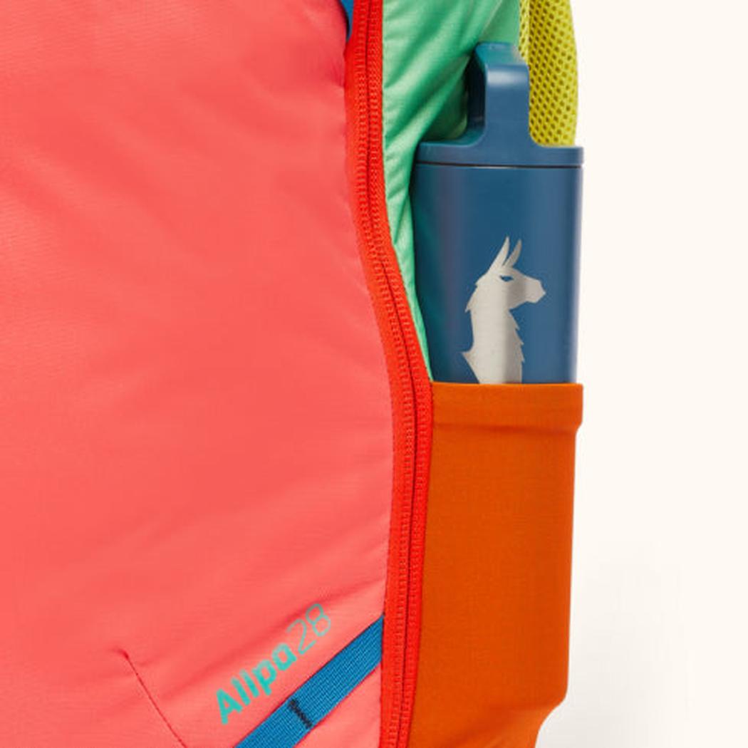 Side pocket of the Cotopaxi Allpa 28L Travel Pack in Del Dia showing a blue water bottle with a llama logo.