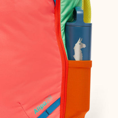 Side pocket of the Cotopaxi Allpa 28L Travel Pack in Del Dia showing a blue water bottle with a llama logo.