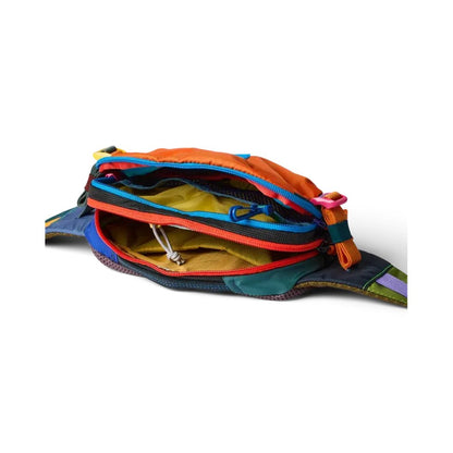 A top-down view of the Cotopaxi Allpa X 1.5L Hip Pack - Del Dia showing its colorful zippers and interior against a white background.