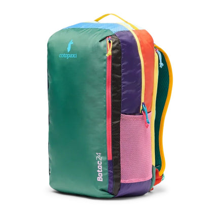 A front view of the Cotopaxi Batac 24L Pack in Del Dia II with a pink mesh pocket and colorful zippers against a white background.