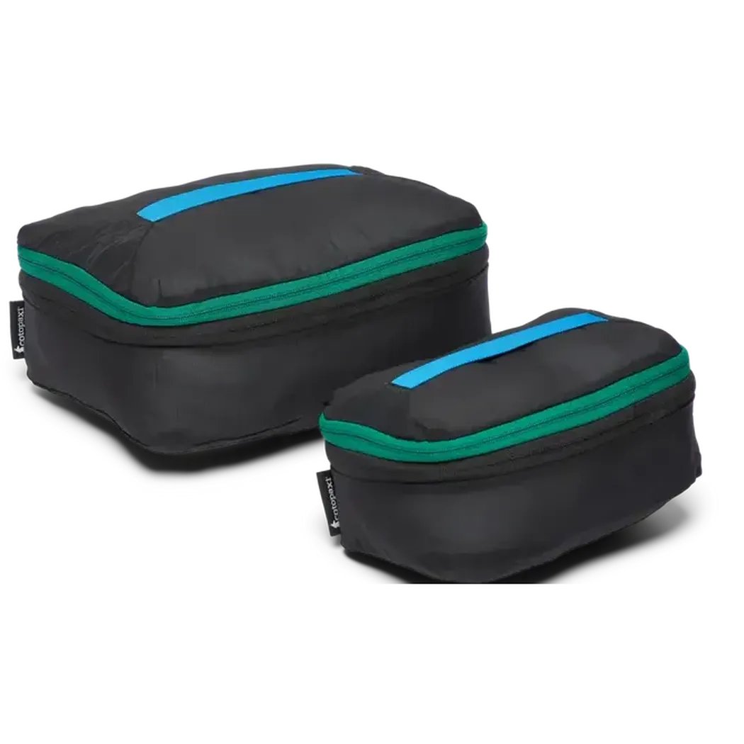 Two black Cotopaxi Cubo Expandable Packing Cube Set travel accessories with green and blue accents, front view against a white background.