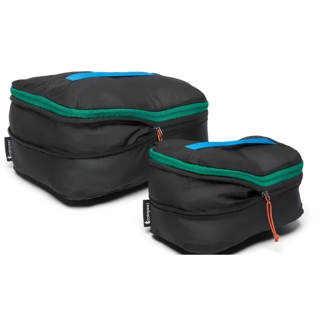 Two black Cotopaxi Cubo Expandable Packing Cube Sets with green zippers and blue top handles sit against a white background.