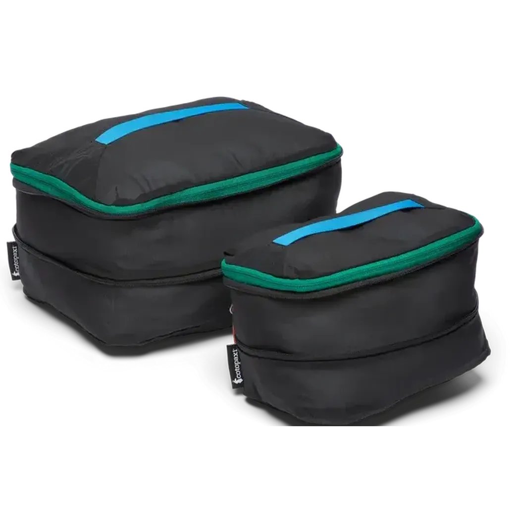 Two black Cotopaxi Cubo Expandable Packing Cube Sets with blue and green accents sit on a white background.