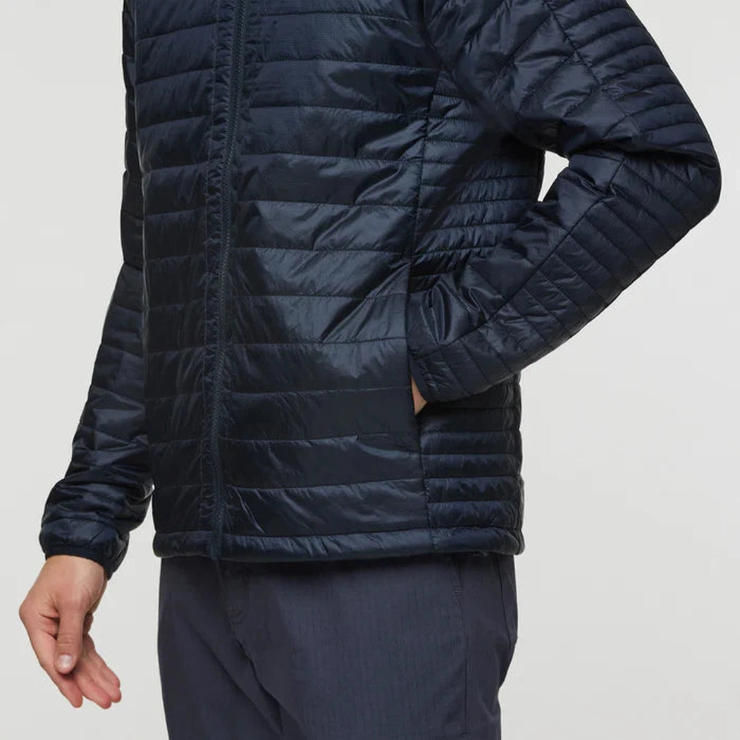 Side view of the Cotopaxi Men's Capa Insulated Hooded jacket in Carbon, showing the front pocket and a model wearing it against a plain background.