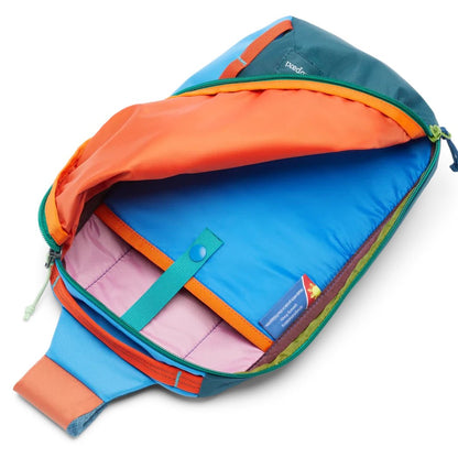 The Cotopaxi Todo 8L Sling in Del Dia color is shown open, displaying its bright blue interior and orange accents against a white background.