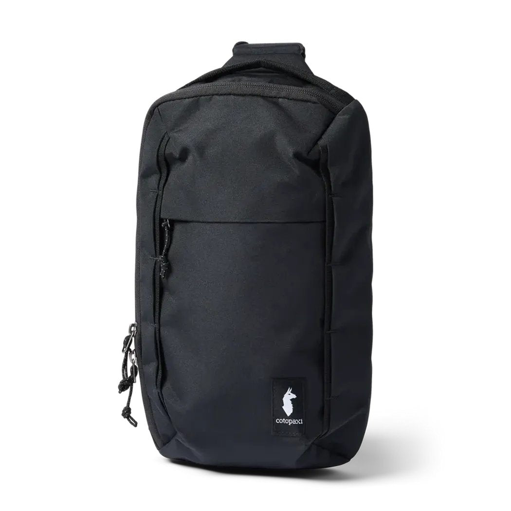 A front view of the black Cotopaxi Todo 8L Sling with a zippered pocket and logo patch against a white background.