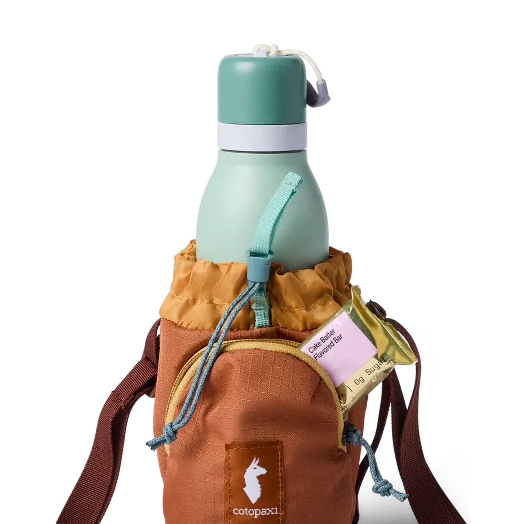 A front view of the Cotopaxi Todo Water Bottle Sling in Honeycomb/Whiskey showing the water bottle and brown strap against a white background.