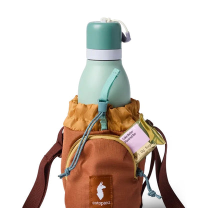 A front view of the Cotopaxi Todo Water Bottle Sling in Honeycomb/Whiskey showing the water bottle and brown strap against a white background.