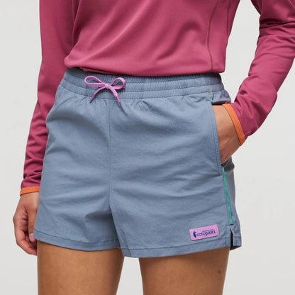 A front view of the Cotopaxi Women's Brinco Short in Tempest color with a pink drawstring and a model wearing it.