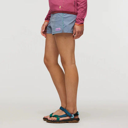 Side view of the Cotopaxi Women's Brinco Short in Tempest on a model wearing teal sandals against a white background.