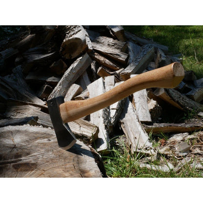A Hudson Bay Camp Axe with a 18" handle rests on a log in front of a pile of firewood.
