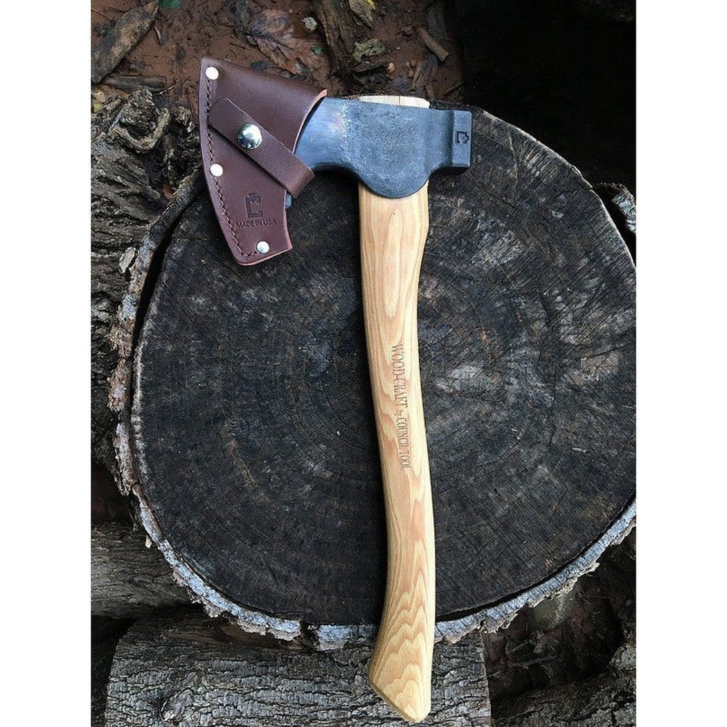 A Council Tool Co. Wood-Craft Camp Carver axe with a 16" handle rests on a tree stump.