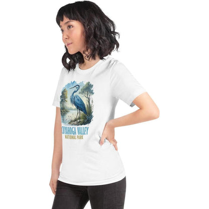 A woman in a side view wears the white Cuyahoga Valley Clothing Company CVNP Blue Heron T - Shirt with a blue heron graphic on the front.