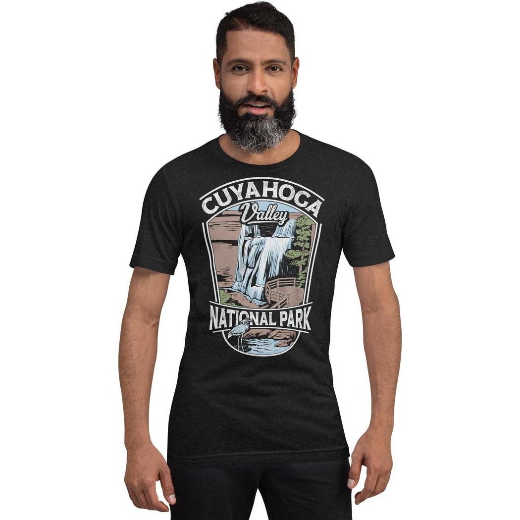 A man wearing a black heather Cuyahoga Valley Clothing Company CVNP Brandywine Falls T - Shirt stands against a white background.