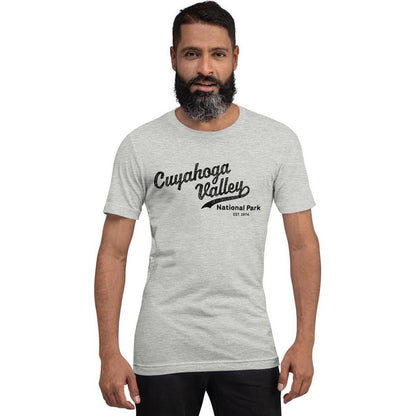 A front view of a man wearing a gray Cuyahoga Valley National Park vintage script t - shirt against a white background.