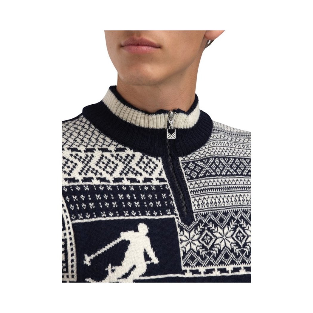 A close-up of the Dale Of Norway Mens History Sweater-SAMPLE in Nvy, showing the zipper and ski graphic on a model.