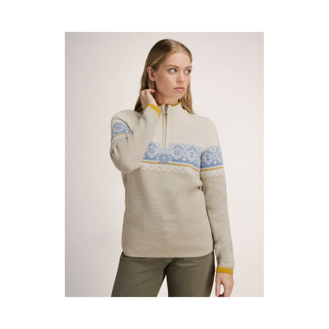 A woman wearing the Dale Of Norway Moritz Fem Sweater-SAMPLE in NvyBrnzBeigeOff stands against a plain background.