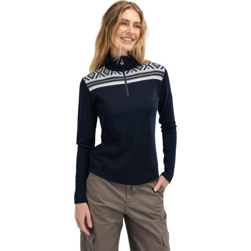 A woman wearing the Dale Of Norway Women's Cortina Basic Sweater in Navy Off White stands against a white background.