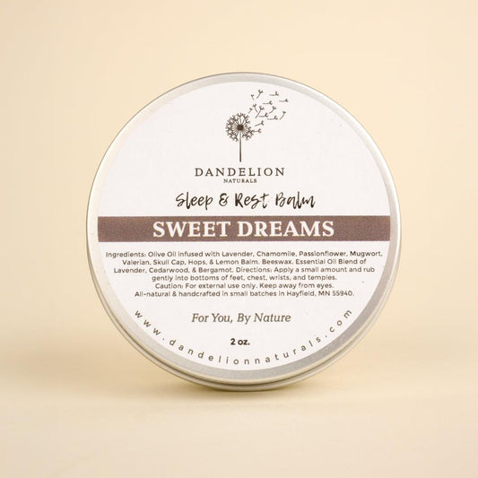 A round tin of Dandelion Naturals Sweet Dreams Balm for Sleep Aid sits centered against a plain beige background.