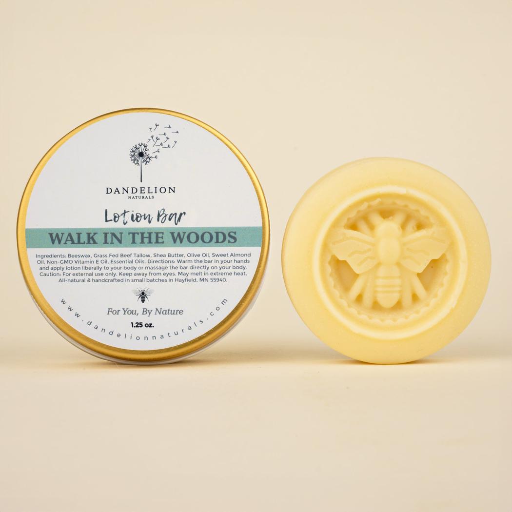 A front view of the Dandelion Naturals Walk In The Woods lotion bar with a bee design on the front against a light background.