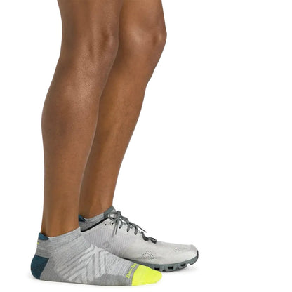 Side view of the Darn Tough Men's Run No Show Tab Ultra-Lightweight Running Socks in Gray on a model's feet against a white background.