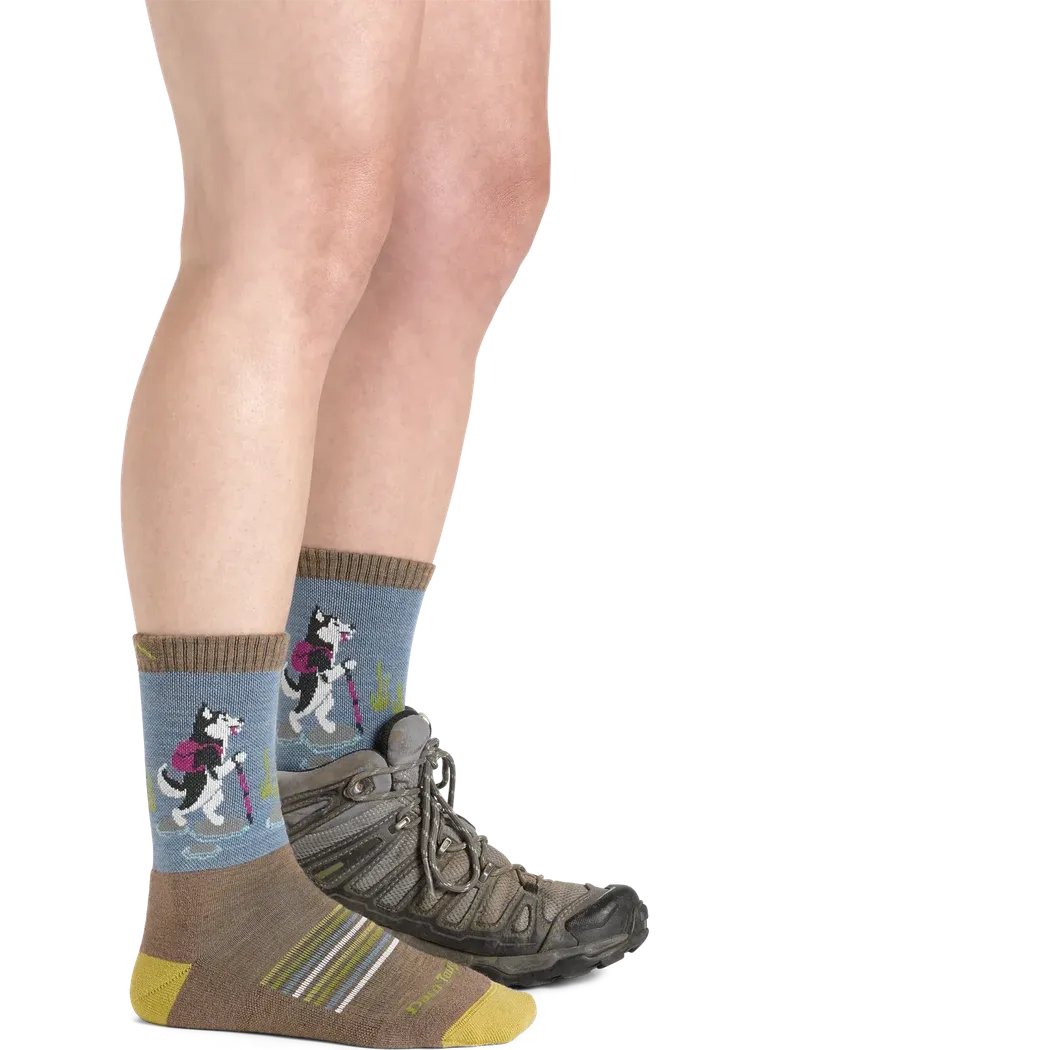 Side view of the Darn Tough Women's Critter Club Micro Crew Lightweight with Cushion socks in Bark showing the dog graphic and brown toe on a model wearing hiking shoes against a white background.