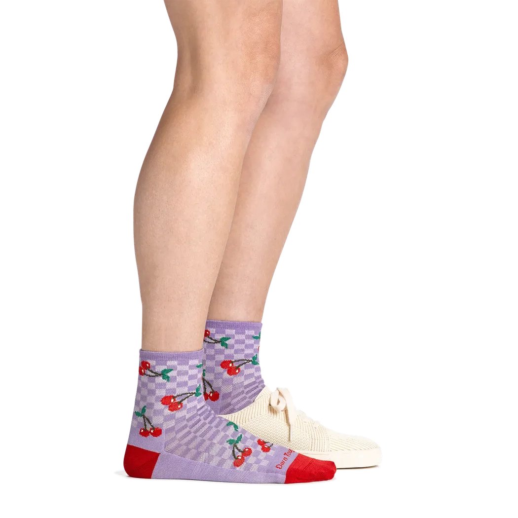 Side view of the Darn Tough Women's Fruit Stand Shorty Lightweight Lifestyle Sock in Country Blue on a model wearing a white sneaker against a white background.