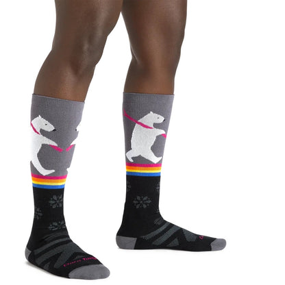 A person wearing black Darn Tough Women's Thermolite Due North Over-the-Calf Midweight Ski & Snowboard Socks with gray tops and colorful accents, photographed from the side against a white background.
