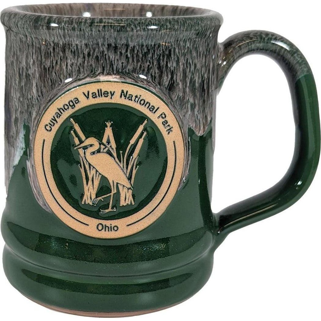 A front view of the Deneen Pottery Cuyahoga Valley National Park Mug in Forest color showing the logo and handle.