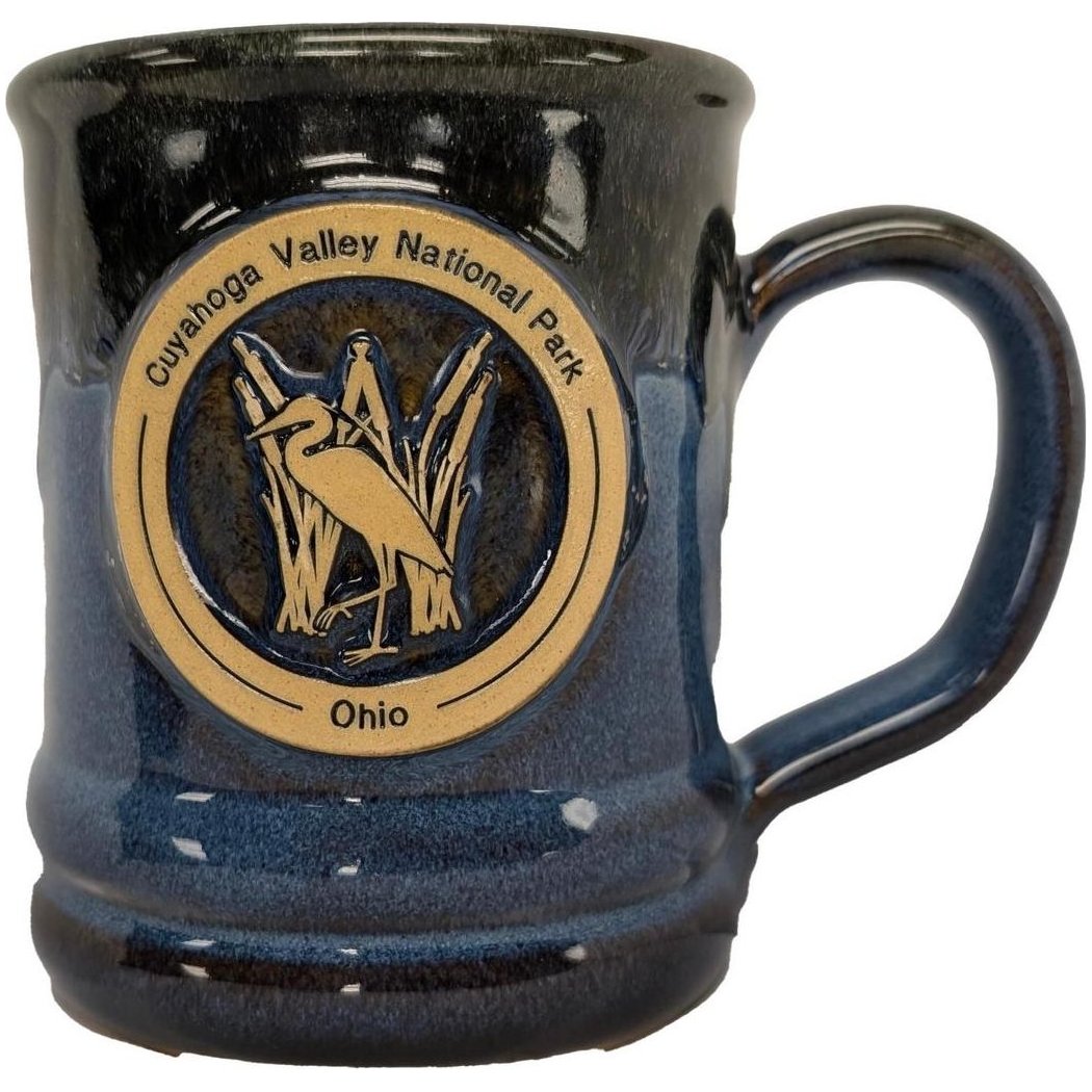 A front view of the Deneen Pottery Cuyahoga Valley National Park Mug in Forest color showing the logo and handle.