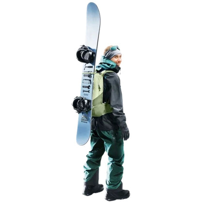 Side view of the Deuter Freecline 15 backpack in Black worn by a model with a snowboard against a white background.