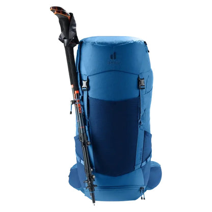 Back view of the Deuter Futura 32 backpack in Nightblue Baltic with trekking poles attached against a white background.