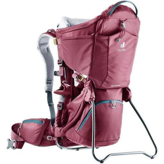 Side view of the Deuter Kid Comfort in Maroon showing the padded shoulder straps and metal frame against a white background.