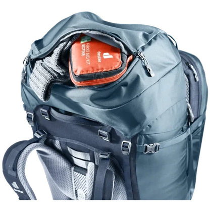 A top-down view of the Deuter Voyager 65+10 backpack in Atlantic Ink showing the front pocket with a first aid kit and a gray sweater inside against a white background.